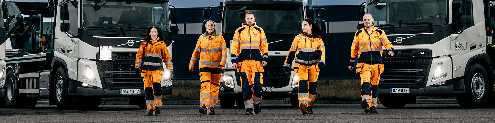 Medarbetare på PreZero går framför lastbilar